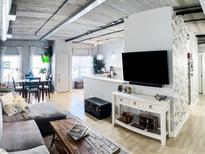 Bright living room features a dining area, hardwood floors, exposed pipes, and natural light from large windows at 800 Peachtree Ne St # 1319, Atlanta, GA 30308