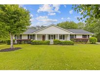 Charming home featuring a well-manicured lawn, attractive shrubbery and a welcoming front porch at 256 Teresa Ln, Loganville, GA 30052