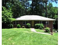 Charming brick home with a well-maintained lawn and mature trees at 1305 Lenox Cir, Atlanta, GA 30306
