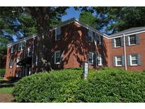 Charming red brick apartment building with mature landscaping and gray shutters on a sunny day at 1332 Euclid Ave # C, Atlanta, GA 30307