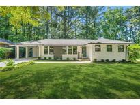 Charming brick home with manicured lawn, modern windows, and convenient carport at 3337 Toney Dr, Decatur, GA 30032
