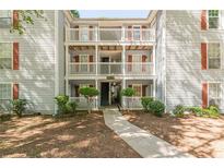 Apartment building exterior featuring multiple balconies, red shutters, and landscaped surroundings at 215 Cobblestone Trl, Avondale Estates, GA 30002