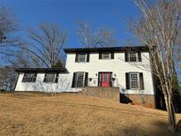 Charming two-story home featuring a red front door, black shutters, and a well-maintained lawn at 4756 Manly Ct, Stone Mountain, GA 30088