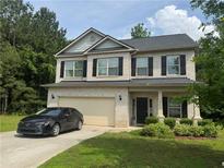 Charming two-story home with a well-manicured lawn and an attached two-car garage at 12351 Styron Dr, Hampton, GA 30228