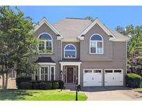 Charming two-story home featuring a well-manicured lawn, two-car garage, and stylish architectural details at 4527 Village Springs Run, Dunwoody, GA 30338