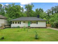 Charming ranch-style home with a well-maintained lawn, white siding, and a vibrant, colorful front door at 2049 Rector Sw Dr, Atlanta, GA 30311