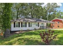 Charming single-story home with white brick, dark shutters, and a well-manicured lawn at 623 Montevista Sw St, Atlanta, GA 30310