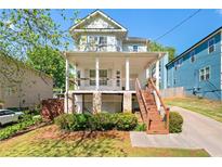 Charming two-story home with a covered front porch and well-maintained landscaping at 628 Warren Ave, Scottdale, GA 30079