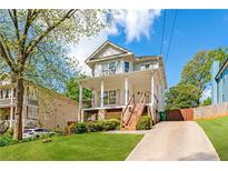 Inviting two-story home with a charming front porch and well-manicured lawn at 628 Warren Ave, Scottdale, GA 30079