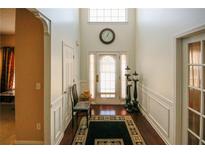 Bright foyer with hardwood floors, high ceilings, and decorative lighting fixtures near the white front door at 3554 Umatilla Sw Ln, South Fulton, GA 30331