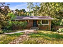Charming brick home featuring mature trees, a well-kept lawn, and a cozy, inviting front porch at 511 Oakview Rd, Decatur, GA 30030