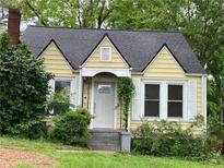 Charming yellow house with white trim, gabled roof, chimney, and welcoming front porch at 1238 Trenton St, Atlanta, GA 30316