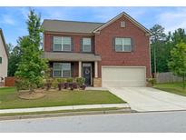 Charming two-story brick home with well-maintained landscaping and a two-car garage at 3062 Hawthorn Farm Blvd, Loganville, GA 30052