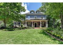 Charming two-story home with manicured lawn, complemented by lush landscaping and mature trees at 3715 Horizon Ct, Cumming, GA 30041