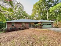 Charming brick ranch home with mature trees and attached garage in a wooded setting at 1512 Pine Cir, Lawrenceville, GA 30044