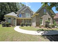 Charming two-story brick home with manicured lawn and inviting walkway, offers a warm and welcoming curb appeal at 375 Beracah Tr Southwest Sw Trl, Atlanta, GA 30331