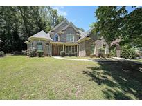 Charming two-story home with stone accents, lush lawn, and mature trees at 375 Beracah Tr Southwest Sw Trl, Atlanta, GA 30331