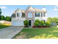 Charming two-story home with a well-manicured lawn, two-car garage, and a brick facade at 2837 Lakewater Way, Snellville, GA 30039
