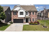 Charming two-story brick home with a well-manicured lawn and a two car garage at 4171 Towncastle Ln, Buford, GA 30518