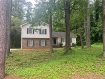 Charming two-story home featuring brick accents and complemented by lush, mature trees at 752 Roxboro Trce, Lawrenceville, GA 30044