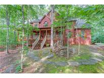 Secluded brick home with a charming front porch, stone accents, and inviting stairway at 4975 Duncans Lake Dr, Buford, GA 30519