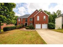 Charming two-story brick home with a well-manicured lawn and a two-car garage at 1045 Paper Creek Dr, Lawrenceville, GA 30046