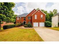 Charming two-story brick home with a well-manicured lawn and an attached two-car garage at 1045 Paper Creek Dr, Lawrenceville, GA 30046