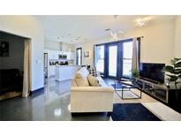 Open concept living room featuring a modern kitchen and access to a balcony with lots of natural light at 1195 Milton Se Ter # 1109, Atlanta, GA 30315