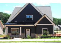 Beautiful two-story home featuring dark siding, white trim, and a covered front porch at 135 Old Alabama Rd, Emerson, GA 30137