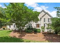 Stately home featuring lush landscaping, mulched beds and a symmetrical facade under a bright blue sky at 4223 N Mountain Ne Rd, Marietta, GA 30066