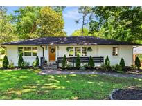 Charming single-story home featuring a white brick exterior, manicured lawn and well-maintained landscaping at 1790 Shirley Sw St, Atlanta, GA 30310