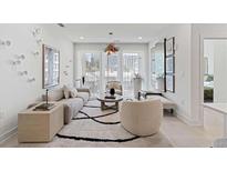 Bright living room featuring a modern sofa, stylish decor, large windows, and a decorative rug on light wood floors at 775 Juniper St # 212, Atlanta, GA 30308