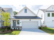 Charming craftsman-style home showcasing a clean white facade, a black metal roof, and an attached garage at 1818 Butterfly Way, Marietta, GA 30066