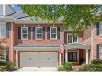 Charming brick home with a two-car garage, black shutters and an inviting front entrance at 4905 Village Green Dr, Roswell, GA 30075