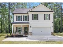 Charming two-story home with white siding, black shutters, and attached two car garage at 115 Haven Brook Way, Douglasville, GA 30134