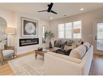 Bright living room featuring a modern fireplace, ceiling fan, stylish decor, and lots of natural light at 3350 Cranston Ln, Kennesaw, GA 30144