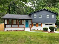 Charming split-level home with updated white brick, gray siding, wood accents, and a vibrant blue front door at 3640 Narron Dr, Atlanta, GA 30331