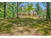 Inviting front porch with a rocking chair offering views of the surrounding yard and trees at 4950 Creel Rd, Chattahoochee Hills, GA 30213