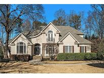 Charming two-story home with a manicured front yard, elegant architectural details, and a small balcony at 5105 Deerlake Dr, Alpharetta, GA 30005