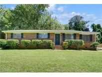 Charming brick home features a well-manicured lawn and lush landscaping at 606 Evergreen Dr, Woodstock, GA 30188