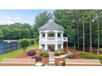 Scenic gazebo near tennis court with stone base, white railings and stairs to wooded area at 161 Highgrove Dr, Suwanee, GA 30024