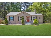 Charming single-story home with a well-maintained lawn and a cozy front porch at 2115 Pinehurst Dr, East Point, GA 30344