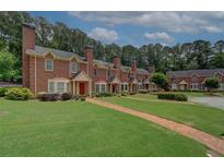 Charming townhomes featuring brick exteriors, lush green lawns, and inviting pathways at 2565 Holcomb Springs Dr, Alpharetta, GA 30022