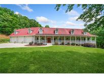 Stunning home with a red roof, wraparound porch, and well-manicured lawn at 425 Chadwick Pl, Canton, GA 30114