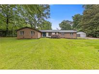 Charming brick ranch-style home with mature trees and lush lawn at 679 Creek View Dr, Lawrenceville, GA 30044