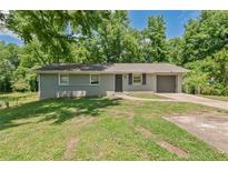 Charming single-story home with attached garage, large front yard, and mature trees at 2172 Se Wakita Se Dr, Marietta, GA 30060