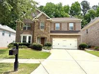 Beautiful two-story brick home with a well-manicured lawn, two-car garage, and welcoming front entrance at 3389 Rosecliff Trce, Buford, GA 30519