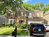 Charming two-story brick and stone home with a well-manicured lawn and attached two-car garage at 3389 Rosecliff Trce, Buford, GA 30519