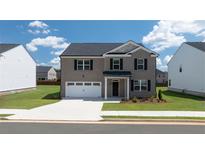 Charming two-story home with gray brick, black shutters, attached two-car garage and a well-manicured lawn at 625 Kimberwick Dr, Locust Grove, GA 30248
