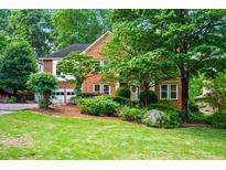 Charming two-story brick home with a well-manicured lawn and lush landscaping at 2610 Chadwick Rd, Marietta, GA 30066